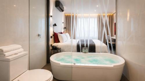 a bathroom with a tub and a bedroom with a bed at BTH Hotel – Boutique Concept in Lima