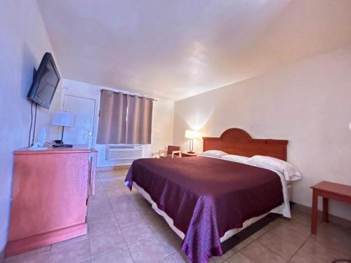 a bedroom with a bed and a flat screen tv at Kings Suites Near Naval Base I-95 Kingsland in Kingsland