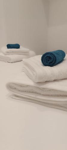 a stack of white towels on a white bed at Loutraki Cozy Loft in Loutraki