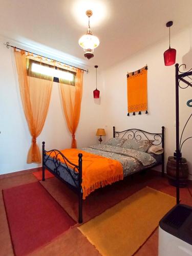 a bedroom with a bed with an orange blanket at Lazy Lizard by the Ocean in Seixal