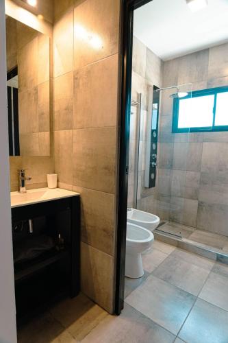 a bathroom with a toilet and a sink and a shower at Casa Tannat by Vindecaf in Cafayate