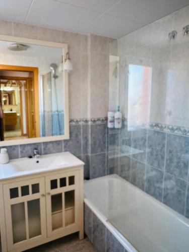 a bathroom with a tub and a sink and a mirror at Apartamento con terraza y piscina en Malgrat de Mar in Malgrat de Mar