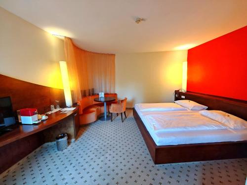 a hotel room with a bed and a desk and a television at Hotel Öhlknechthof in Horn