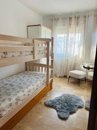 a bedroom with two bunk beds and a rug at Apartamento con terraza y piscina en Malgrat de Mar in Malgrat de Mar