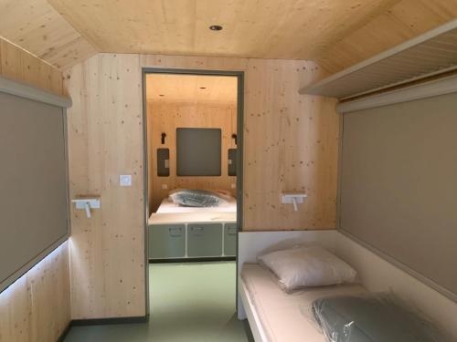 a small room with two beds and a mirror at Logis Hôtel Restaurant Le 1050 in Saint-Agrève