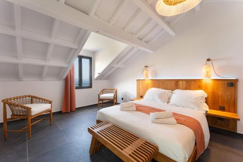 a bedroom with a large bed and a chair at L'Astrolabe in Vieux-Fort