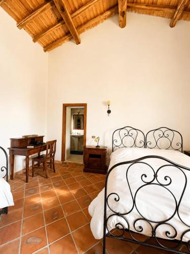 a bedroom with a bed and a desk in a room at Etna 1928 Country House in SantʼAlfio