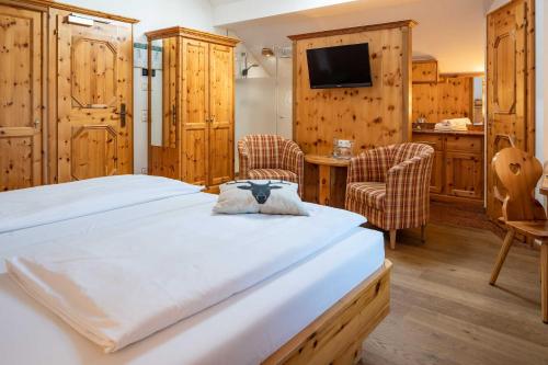a bedroom with a bed and a table and chairs at Landgasthof zum Erdinger Weissbräu in Rosenheim