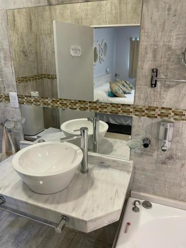 a bathroom with a sink and a large mirror at Ch Loreto Hotel Boutique in Ciudad de Loreto