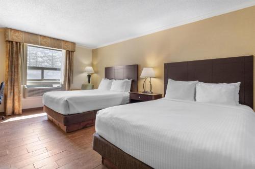 a hotel room with two beds and a window at Best Western Davison Inn in Davison
