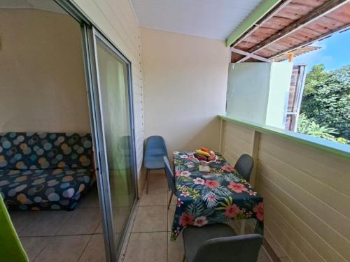 a small room with a couch and a table and chairs at Anajodrey in Saint-Joseph