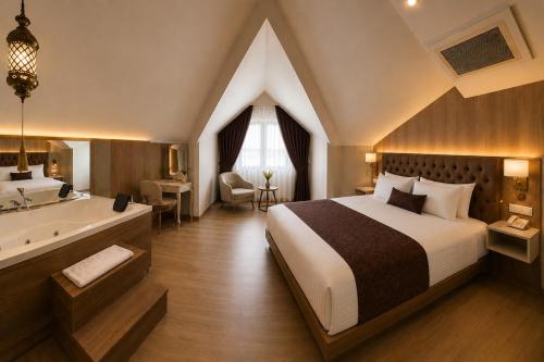 a bedroom with a large bed and a bathtub and a bed and a tub at Anemon Kent Trabzon Otel in Trabzon