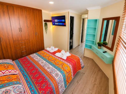 a bedroom with a bed and a dresser and a mirror at Hospedaje Edificio Alejandria in Sogamoso