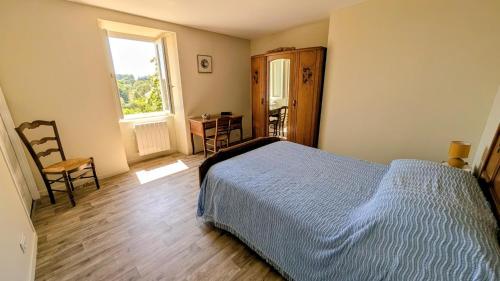 a bedroom with a bed and a window and a desk at Gîte de roger in Blond