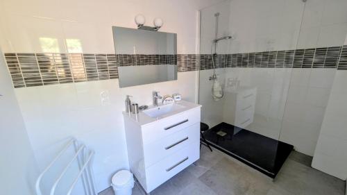 a white bathroom with a sink and a shower at Gîte de roger in Blond