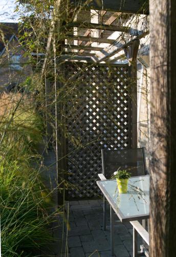a patio with a white table and a fence at Country House Duinhof in De Haan