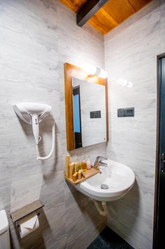 a bathroom with a sink and a mirror at Sunset Hill Resort in Kandy