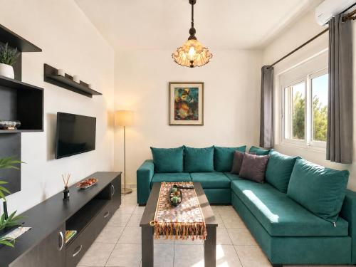a living room with a blue couch and a table at Sun Arise in Porto Rafti