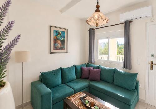 a living room with a green couch and a table at Sun Arise in Porto Rafti