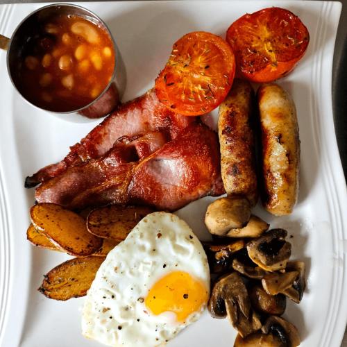 a plate of breakfast food with eggs bacon potatoes and beans at Burlington Berties in Sheringham