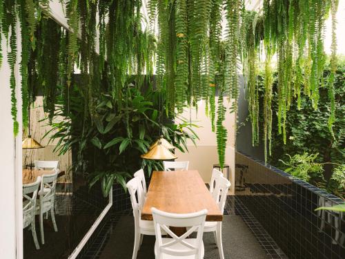 a table and chairs in a restaurant with plants at Fausto by Andean in Lima