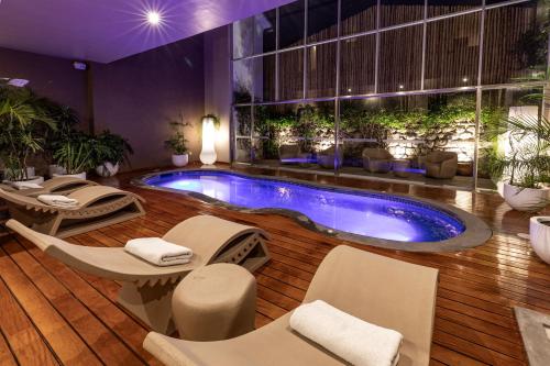 a pool in a hotel room with chairs and a table at Casa Cartagena Boutique Hotel & Spa in Cusco