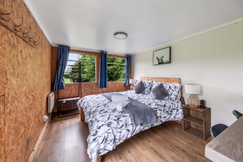 a bedroom with a bed and a window at Farmer's Cabin in Forfar