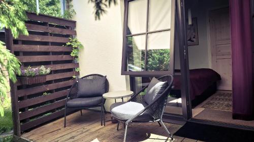 a patio with chairs and a table and a window at Vinoteegi Residents in Kuressaare
