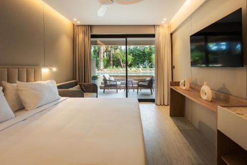 a bedroom with a bed and a living room at Medite Kassandra Resort in Nea Moudania