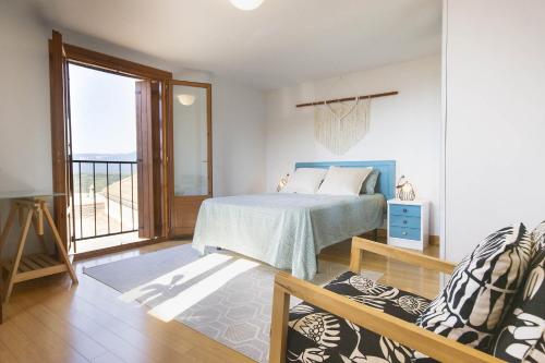 a bedroom with a bed and a couch and a window at Casa El Mirador de Jaca in Jaca