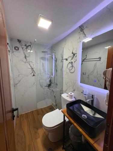 a bathroom with a white toilet and a sink at Guest House Hasko in Gjirokastër
