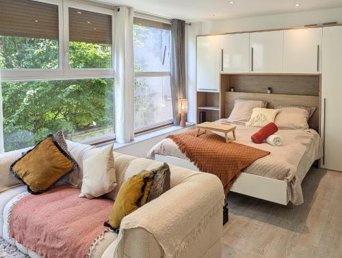 two beds in a room with a couch and windows at Cocoon studio in Gap