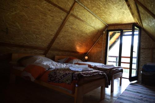two beds in a room with a window at Forest Cabin Ponikve in Čajniče