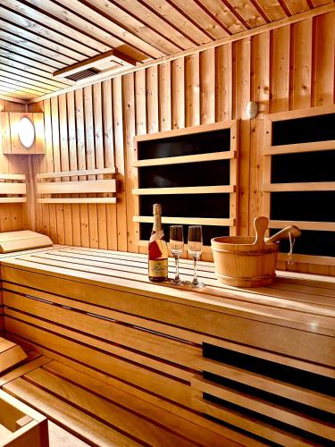 a sauna with two glasses of wine and a bottle at Penzión Lili in Opatovce nad Nitrou