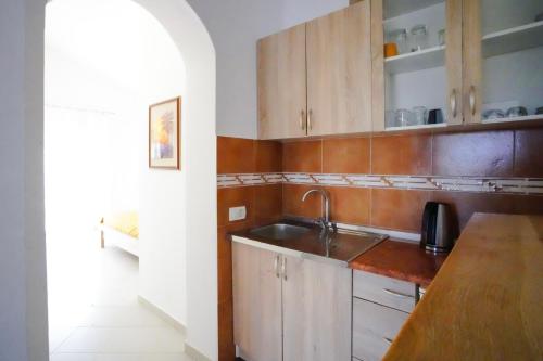 a kitchen with wooden cabinets and a sink at Apartments Sofia in Sutomore