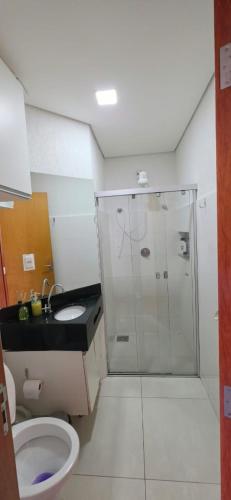 a bathroom with a shower and a toilet and a sink at Estúdio Paris Lagoa Santa in Lagoa Santa