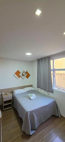 a bedroom with a large bed and a window at Estúdio Paris Lagoa Santa in Lagoa Santa