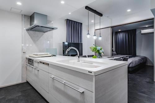 a white kitchen with a sink and a bed at SLL Urban Suites Ebisu in Tokyo