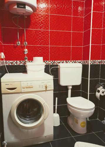 a bathroom with a washing machine and a toilet at Venus Apartman in Brčko