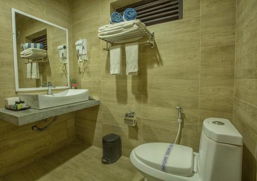 uma casa de banho com um WC branco e um lavatório. em Avenra Beach Hikkaduwa em Hikkaduwa