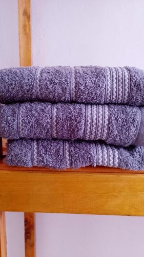 a stack of purple towels on a wooden shelf at "ATARDECER" Departamento a pocos minutos de termas in Chajarí