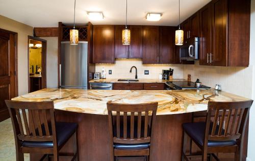 a kitchen with a large island with chairs around it at Lift One Condominiums - Unit 409 in Aspen