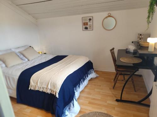 a bedroom with a bed and a desk and a table at La Petite Maison dans la Prairie in Cholet