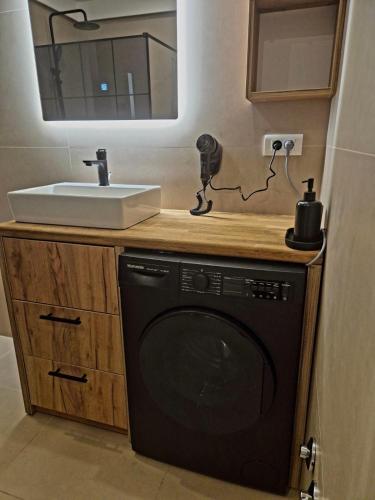 a bathroom with a sink and a washing machine at Ahar in Sarajevo