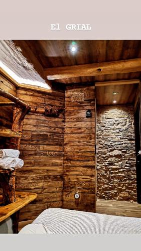 a bedroom with a wooden wall with a door at Casa Antón O Cebreiro in O Cebrero