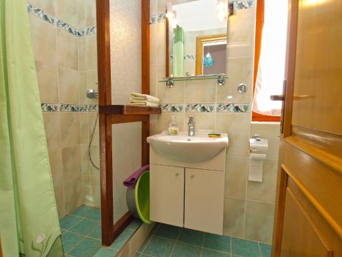 a bathroom with a sink and a toilet and a mirror at Apartments by the Sea 750 in Pješčana Uvala 