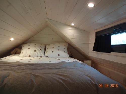 a bed in a small room with a window at Tiny House Climatisée Bernières in Bernières