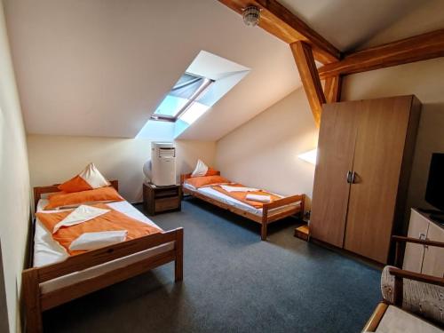 a attic bedroom with two beds and a skylight at City Hotel Siófok in Siófok