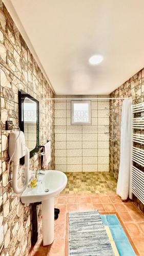 a bathroom with a sink and a stone wall at Hotel New Mars Dades in Aït Idaïr