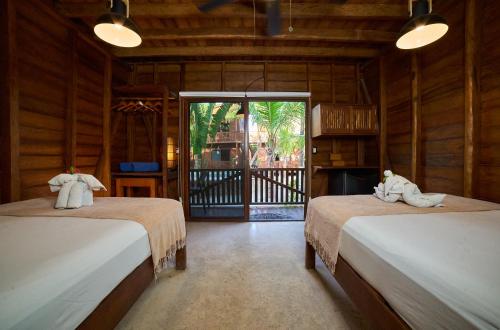 a room with two beds with towels on them at Coconut by ÓOL Hotels in Holbox Island